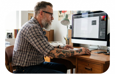 inked up man working on graphic design at staXscale - premium managed hosting